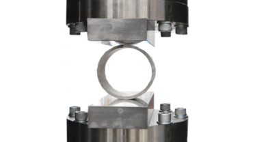 Tijdens de buis-plettest volgens ISO 8492 wordt een ring uit een buis samengedrukt tussen drukplaten.